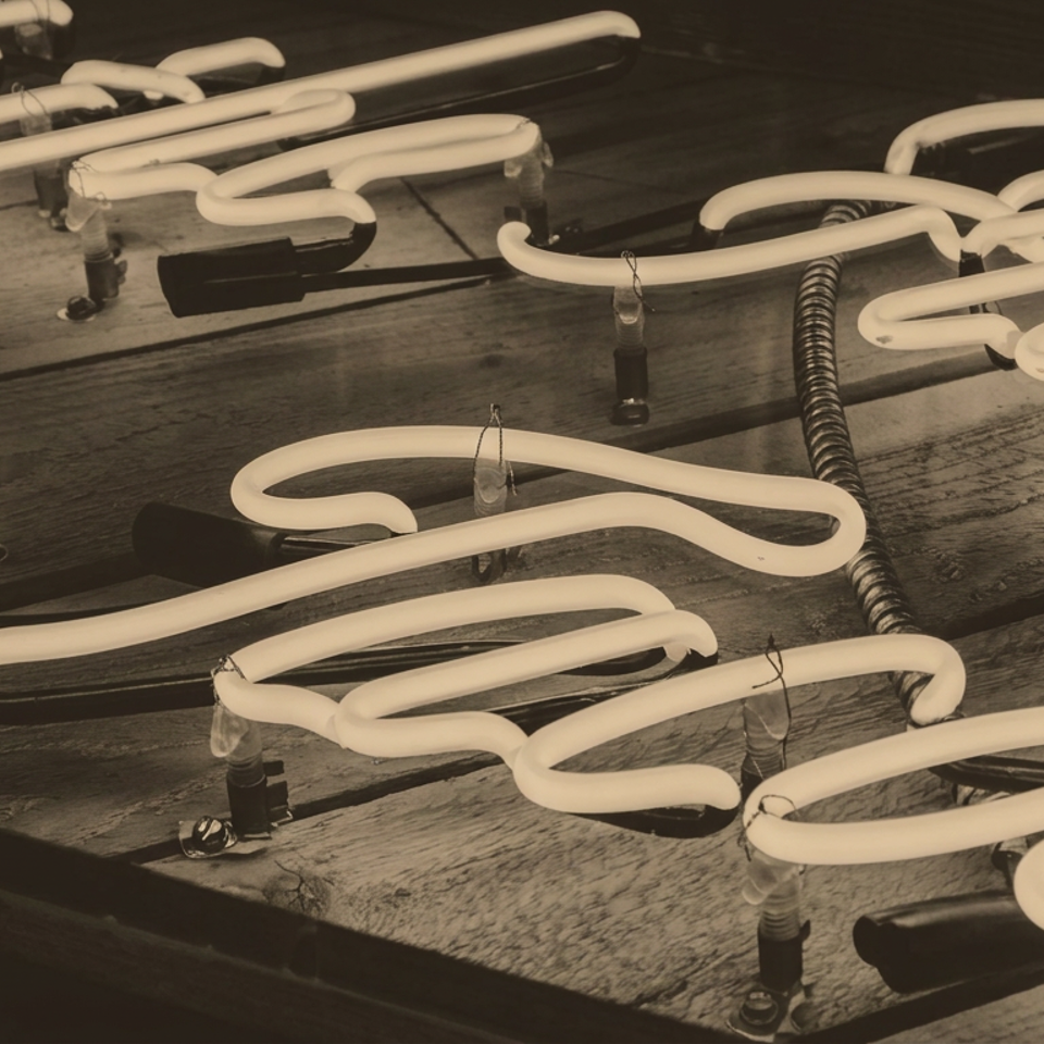 Vintage-style glowing white neon tubes arranged across weathered wooden boards.